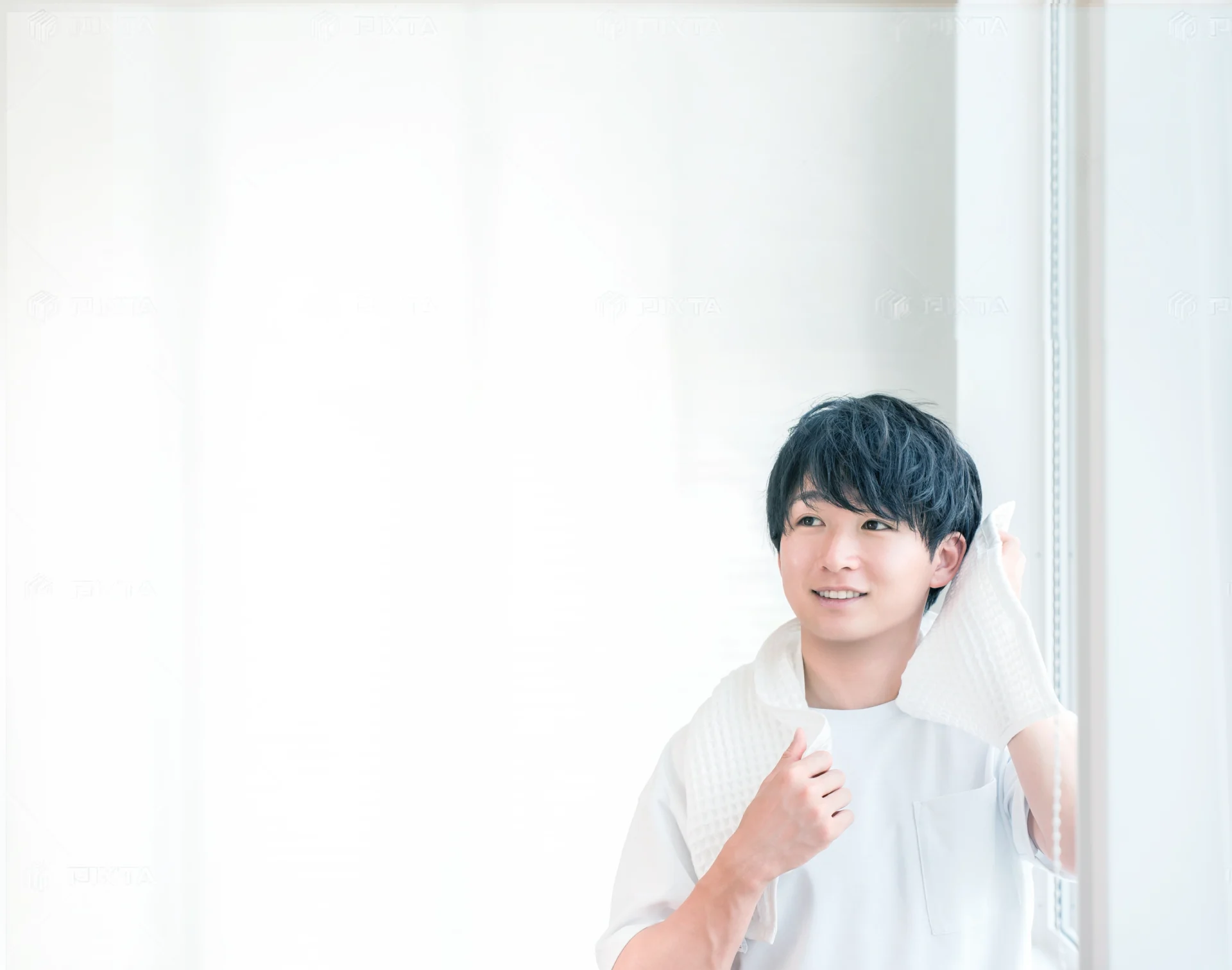 鏡の前で髪の生え際を確認する男性